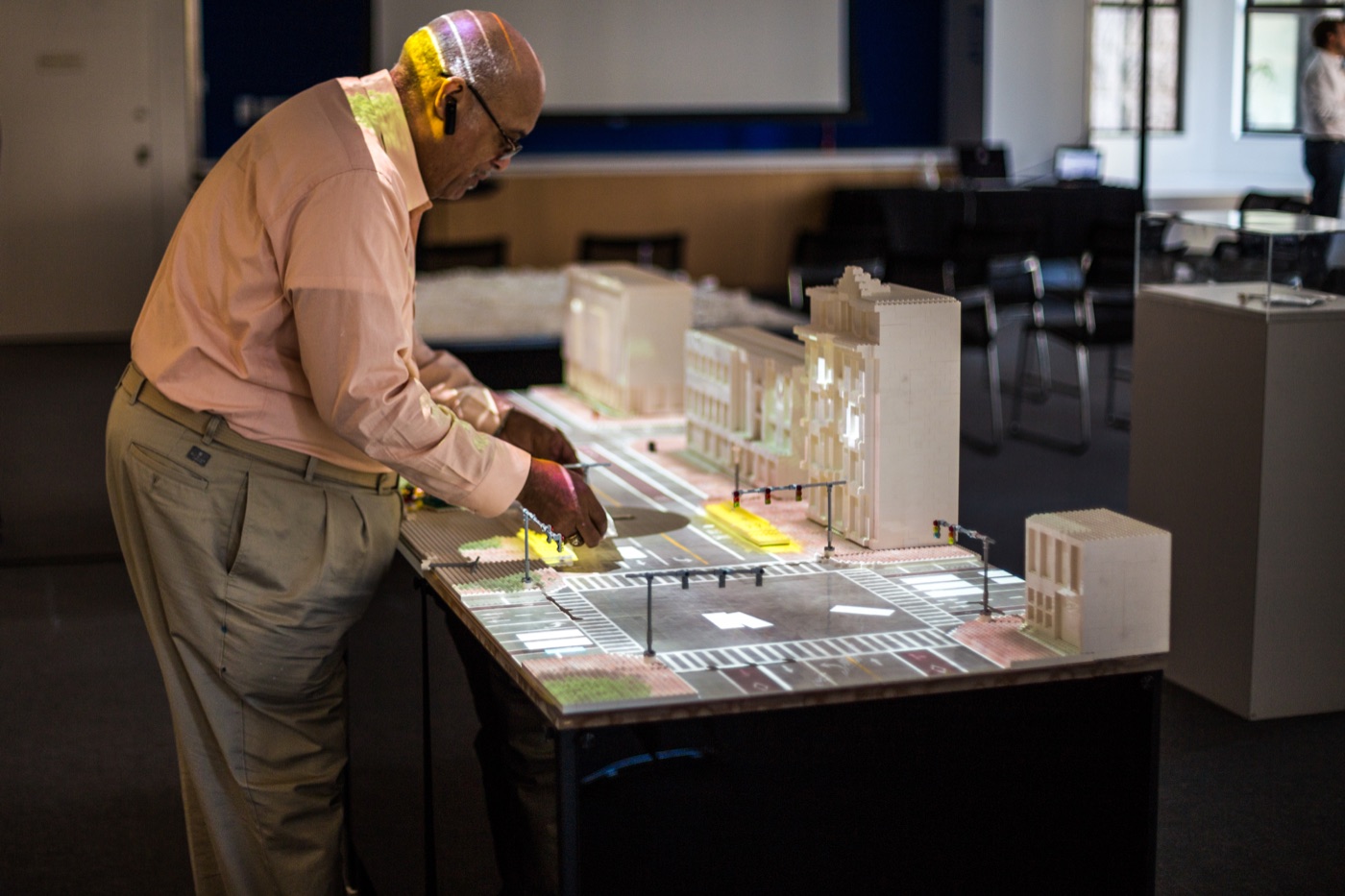Participant adjusting elements on a projection-mapped street model